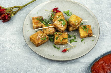 Téléchargez les photos : Assiette avec brochettes de tofu grillées. Tofu au fromage rôti dans l'assiette. - en image libre de droit