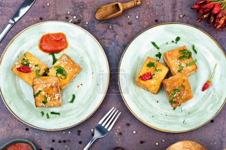 Photo for Roasted soy cheese tofu on the plate. Top view, flat lay. - Royalty Free Image