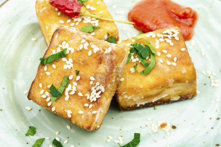 Téléchargez les photos : Tofu au fromage de soja rôti dans l'assiette. Grillades végétariennes. - en image libre de droit