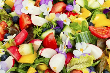 Foto de Ensalada de vitaminas de verduras de primavera decoradas con flores. Alimento saludable de desintoxicación de primavera. De cerca.. - Imagen libre de derechos