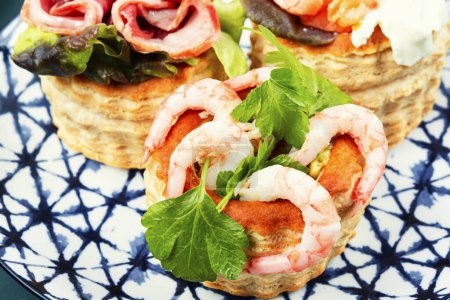 Photo for Appetizing tartlets with fish, shrimp and bacon. Festive table. - Royalty Free Image