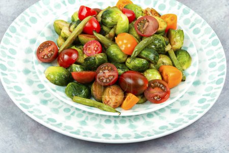 Foto de Ensalada vegetariana de coles de Bruselas asadas, tomates y judías verdes. Concepto de comida vegana saludable. Delicioso almuerzo. - Imagen libre de derechos