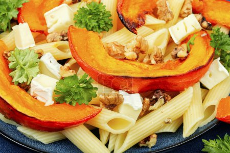 Photo for Appetizing autumn dish, pasta with baked pumpkins, cheese and nuts. - Royalty Free Image