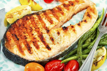 Téléchargez les photos : Steak de saumon frit et salade de légumes. Poissons grillés, aliments sains. - en image libre de droit
