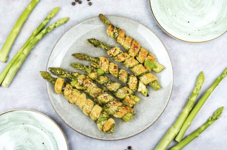 Photo for Baked green asparagus in puff pastry on the plate. Healthy food. - Royalty Free Image