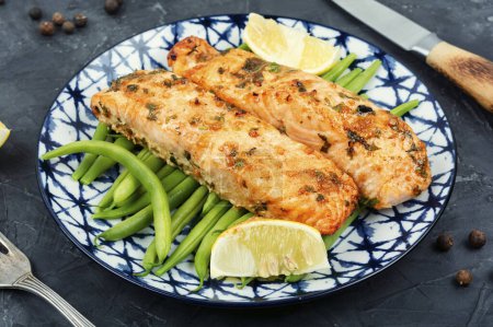 Photo for Delicious baked salmon steaks garnished with bush green beans. Portion of cooked fish. - Royalty Free Image