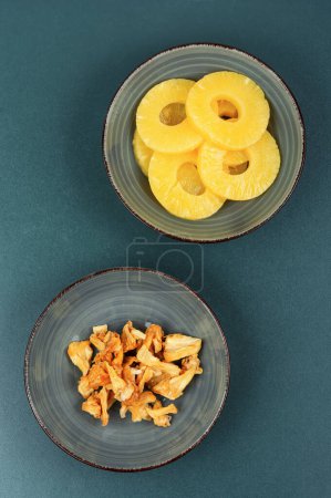 Photo for Dry and fresh pineapples in bowls. Candy pineapples, candied fruits. Fruit snack. - Royalty Free Image