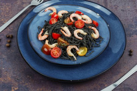 Téléchargez les photos : Spaghettis de haricots noirs végétaliens aux crevettes et tomates. Spaghettis aux pâtes noires cuites. - en image libre de droit
