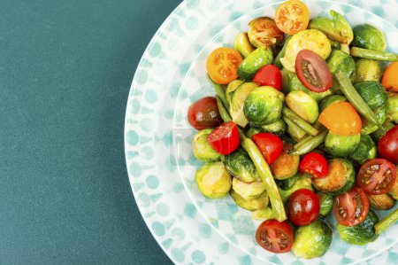 Foto de Ensalada vegetariana de coles de Bruselas asadas, tomates y judías verdes. Concepto de comida vegana saludable. Espacio para texto. - Imagen libre de derechos