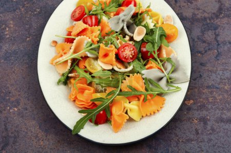 Téléchargez les photos : Salade diététique avec tomates fraîches, herbes et pâtes dans une assiette. - en image libre de droit