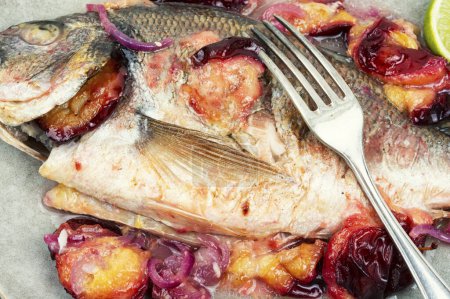 Téléchargez les photos : Dorado poisson cuit avec des prunes. Dorado rôti entier. - en image libre de droit