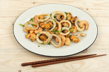 Photo for Roasted mussels, squid and shrimp and chopsticks - Royalty Free Image