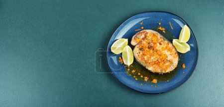 Téléchargez les photos : Assiette de steak de saumon grillé, cuit au four et rôti avec sauce à l'orange. Espace de copie. - en image libre de droit