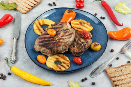Photo for Roasted meat, tenderloin fillet with pineapple rings, grilled steak and ananas. American cuisine. - Royalty Free Image