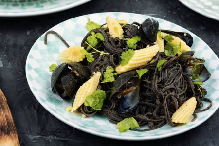 Téléchargez les photos : Pâtes végétaliennes aux haricots noirs aux palourdes, moules. Pâtes méditerranéennes vongole. - en image libre de droit