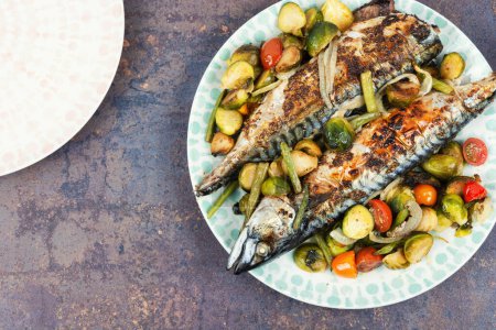 Photo for Roasted mackerel fish on a plate with vegetables. Space for text. - Royalty Free Image