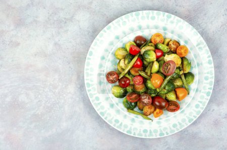 Foto de Ensalada vegetariana de coles de Bruselas asadas, tomates y judías verdes. Comida vegana. Espacio para texto. - Imagen libre de derechos