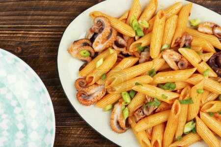 Téléchargez les photos : Macaronis appétissants ou pâtes bouillies avec pieuvre. Pâtes aux fruits de mer sur une vieille table rustique en bois. - en image libre de droit