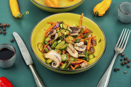 Photo for Fresh Korean salad of cucumber, onion and octopus tentacles. Salad with seafood and vegetables - Royalty Free Image