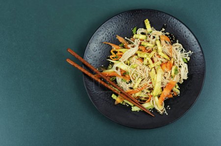 Téléchargez les photos : Salade de champignons enoki et légumes servis sur une assiette noire. Asie nourriture thaïlandaise. Espace de copie pour le texte. - en image libre de droit