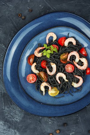 Téléchargez les photos : Spaghetti végétarien aux haricots noirs avec crevettes et tomates. Spaghettis de pâtes aux crevettes. Vue du dessus. - en image libre de droit