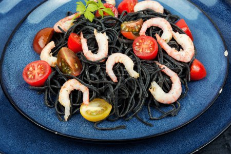 Foto de Espaguetis negros veganos con camarones y tomates. Espaguetis de pasta negra cocida. - Imagen libre de derechos