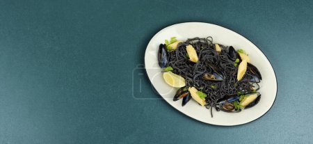 Téléchargez les photos : Pâtes aux haricots noirs végétaliens aux moules. Spaghettis aux fruits de mer. Pâtes vongole. Espace pour le texte. - en image libre de droit