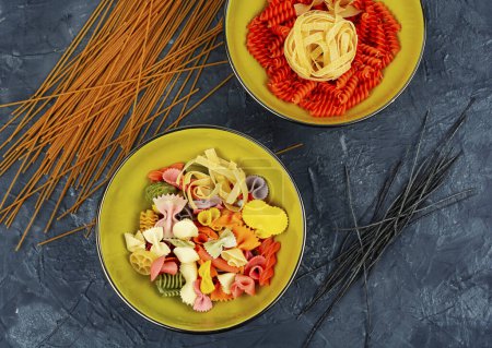 Téléchargez les photos : Un ensemble de macaronis colorés secs, pâtes non cuites et spaghettis. - en image libre de droit