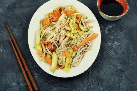 Foto de Ensalada vegana con setas enoki, zanahorias, pepino, semillas de sésamo fritas. Cocina asiática. - Imagen libre de derechos