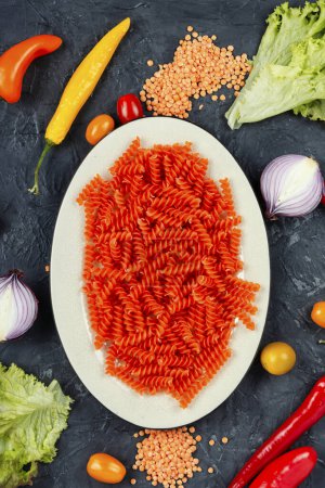 Photo for Uncooked Vegan Pasta, Red Lentil fusilli on the plate. - Royalty Free Image