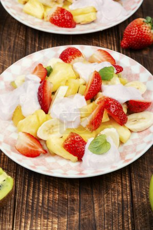 Foto de Ensalada de frutas jugosas de fresas, piña, kiwi y yogur. - Imagen libre de derechos