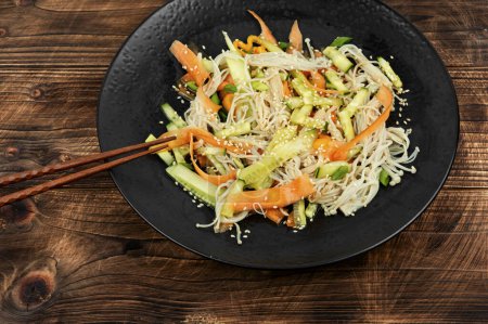 Téléchargez les photos : Salade aux champignons enoki, carottes, concombre, graines de sésame frites. - en image libre de droit