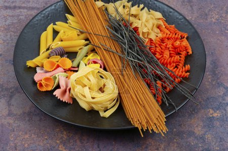 Téléchargez les photos : Différents types de pâtes, nouilles et spaghettis non cuits. - en image libre de droit