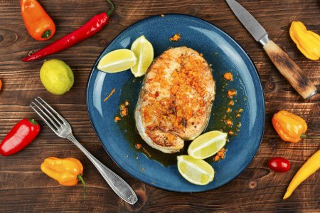 Photo for Roasted salmon or trout steak with orange and lime sauce on wooden table. - Royalty Free Image