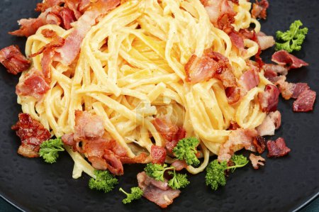Photo for Homemade pasta with fried bacon on a plate, pasta carbonara. Close up. - Royalty Free Image