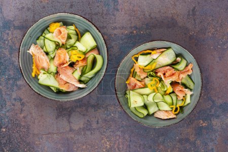 Asian salad with smoked salmon and fresh cucumber. Top view.