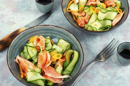 Photo for Salmon salad food, salmon fillet with fresh cucumber. Asian cuisine. - Royalty Free Image