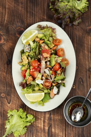 Téléchargez les photos : Salade savoureuse avec légumes frais, fruits de mer et laitue verte fraîche, dans une assiette. Vue du dessus. - en image libre de droit