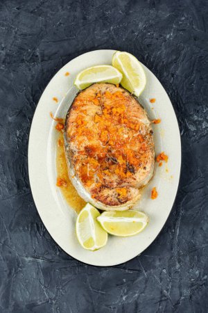 Photo for Plate of roasted trout steak with orange sauce. Top view. - Royalty Free Image