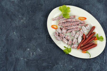 Téléchargez les photos : Salami fumé traditionnel dans une assiette. Espace pour le texte. - en image libre de droit