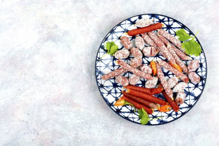 Téléchargez les photos : Trois variétés de saucisse de salami sur une assiette, hors-d'œuvre de viande. Espace de copie. - en image libre de droit