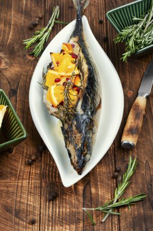Foto de Pescado de caballa a la parrilla con naranjas y romero servido en un plato elegante. - Imagen libre de derechos