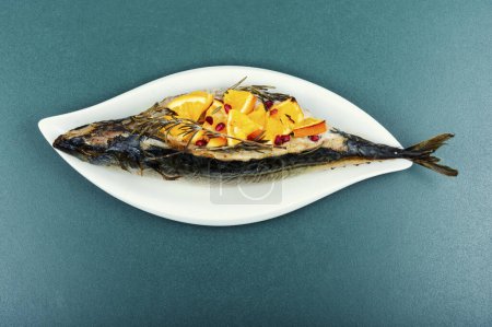 Foto de Asado Scomber. Pescado de caballa a la parrilla al horno con salsa de naranjas y romero servido en un plato elegante. - Imagen libre de derechos