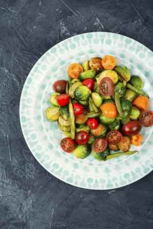 Téléchargez les photos : Salade chaude de choux de Bruxelles frits, tomates et haricots verts. Superaliments. - en image libre de droit