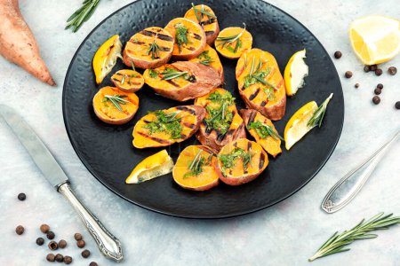 Photo for Roasted sweet potatoes on the grill with herbs. Vegan food concept. - Royalty Free Image