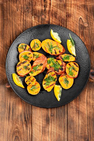 Photo for Grilled sweet potato, batata with olive oil and herbs on wooden background. - Royalty Free Image