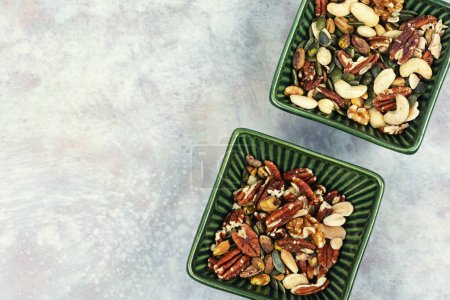 Téléchargez les photos : Mélange de noix sur une table en céramique. Une saine alimentation. Espace de copie. - en image libre de droit