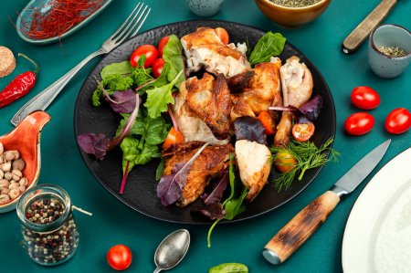 Téléchargez les photos : Des morceaux appétissants de poulet rôti cuit au four avec du vert sur une assiette. Aliments faits maison. - en image libre de droit