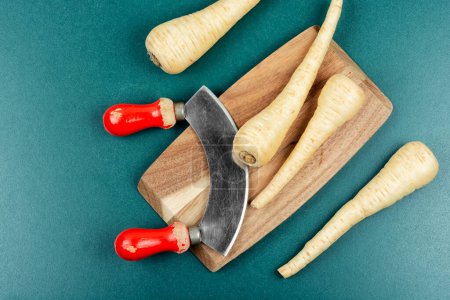 Foto de Raw chirivías raíces y cuchillo en la mesa de la cocina - Imagen libre de derechos
