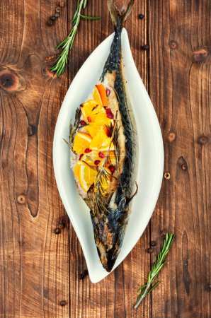Photo for Mackerel fish baked with oranges and rosemary on old rustic wooden table. - Royalty Free Image